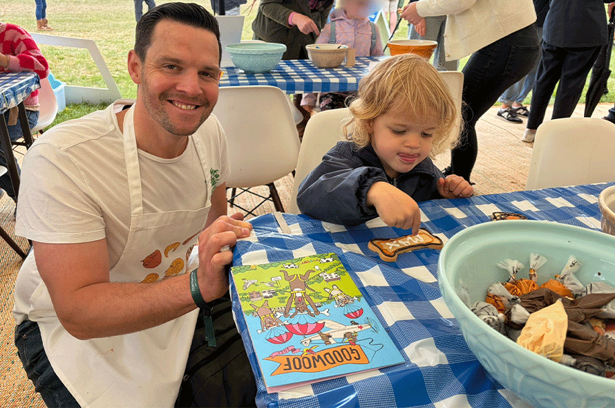 A man and a child enjoy a meal at a table, surrounded by an array of food, highlighting their shared experience.