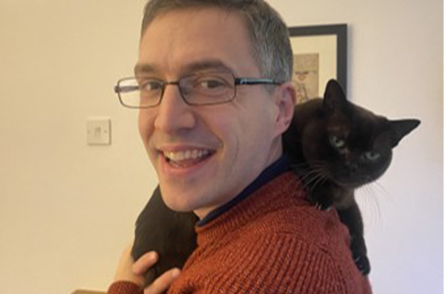 A man holding a black cat
