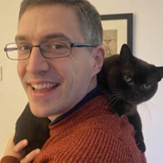 Man holding a black cat.