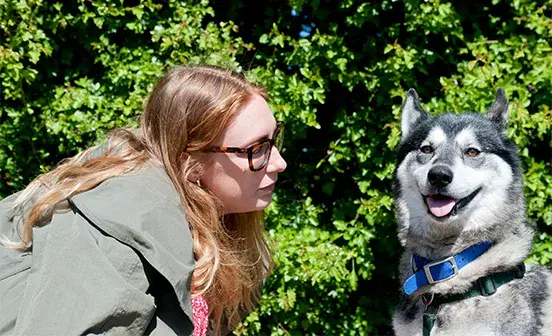 A woman looking as a dog panting