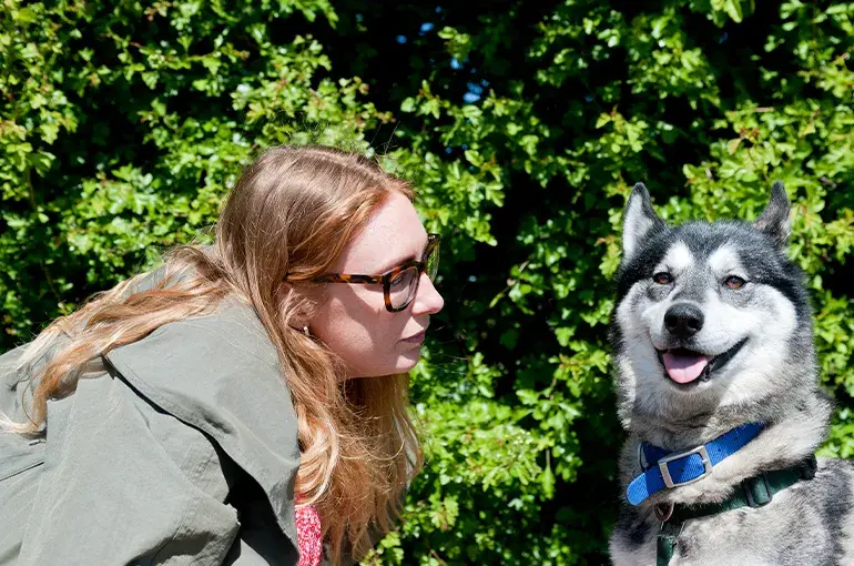 A woman looking as a dog panting
