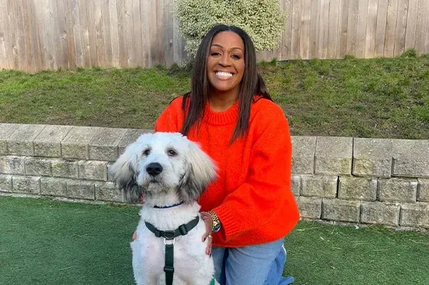 Alison Hammond sitting outside with big white fluffy dog 