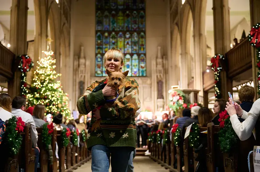 Small dog being held in the aisle of the church