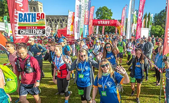Several individuals stroll through a vibrant field, enjoying the outdoors and each other's company.